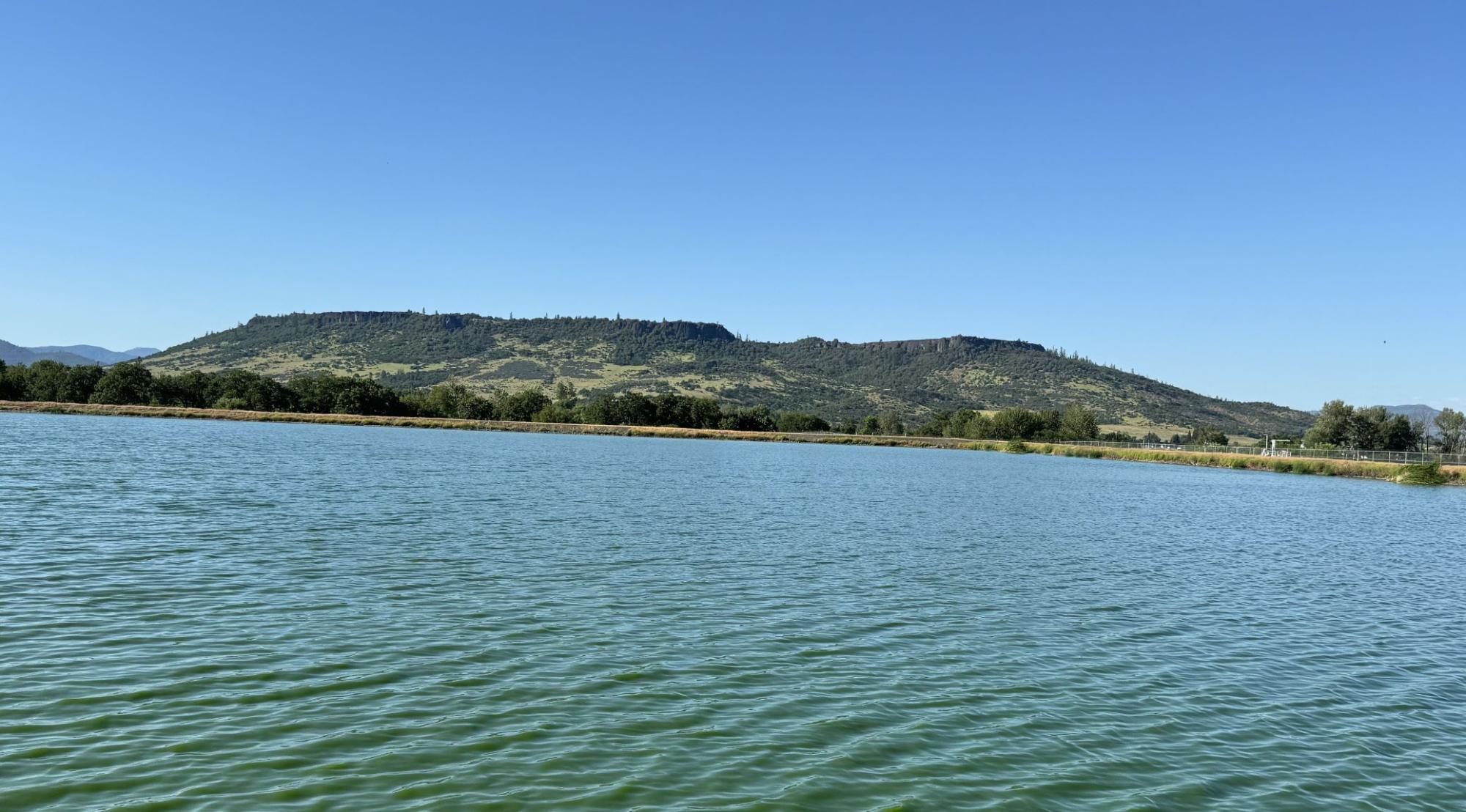 lake in foreground table rock and blue sky in the distance